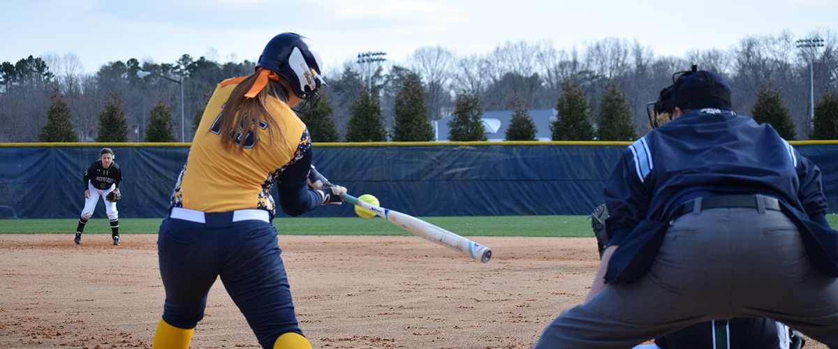 softball player swinging her bat at a pitch