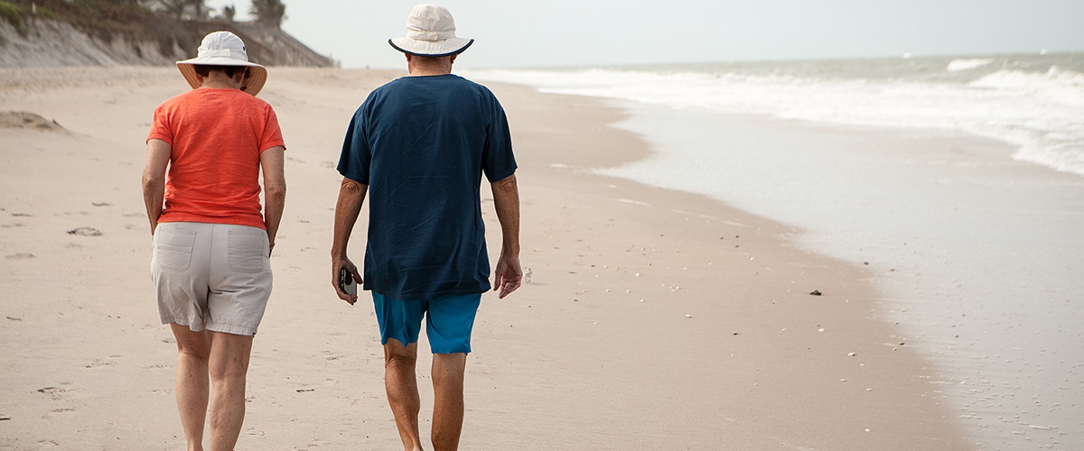 man and woman walking a beach